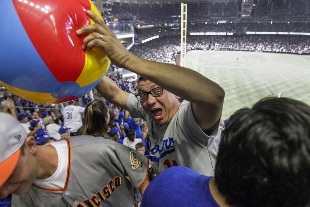 A Pantone 294 Dodgers fan club member grabs a beach ball as he and fellow Pantone 294 fans take up a section of seating during the Dodgers vs. San Diego Padres game at Petco Park.