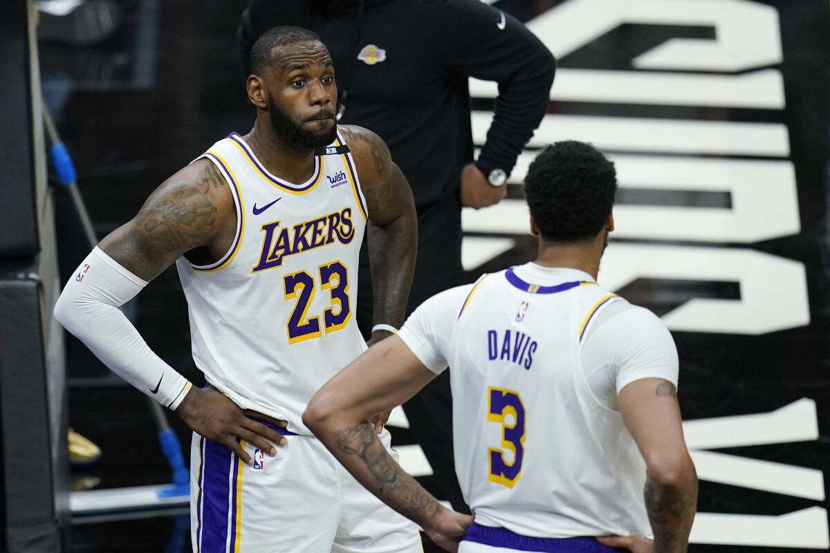 Lakers stars LeBron James and Anthony Davis pause on the court during the second half of the Lakers' loss on Sunday.