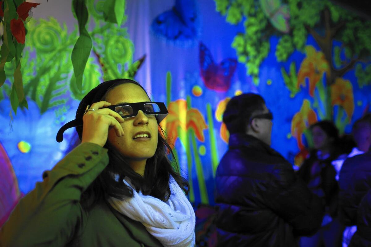 Natasha Khutsishvili, 24, of Agoura Hills uses 3D glasses inside Debi Cable's 3D Black Light Experience, part of the "Night on Broadway" street festival.