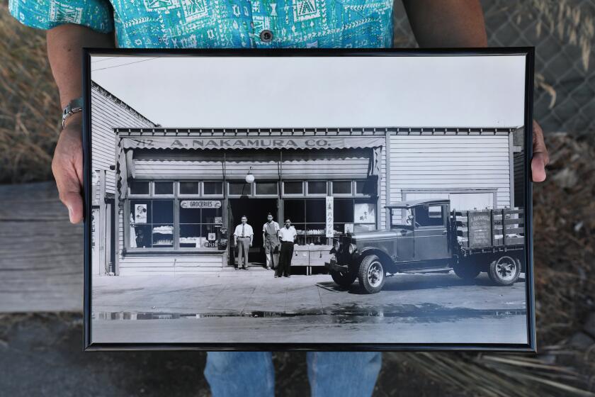 Los Angeles, CA - August 19, 2024: Tim Yamamoto with historic photos of the last remaining buildings in the old Japanese fishing village of Terminal Island that may be demolished to make way for Port of Los Angeles expansion projects. The buildings have been vacant since World War II, when many residents were forced out of the area and imprisoned. Tim Yamamoto, the grandson of the late grocer who owned one of the buildings, has tried with others to get historic status for the buildings before the history is wiped out. (Al Seib / For the Los Angeles Times)