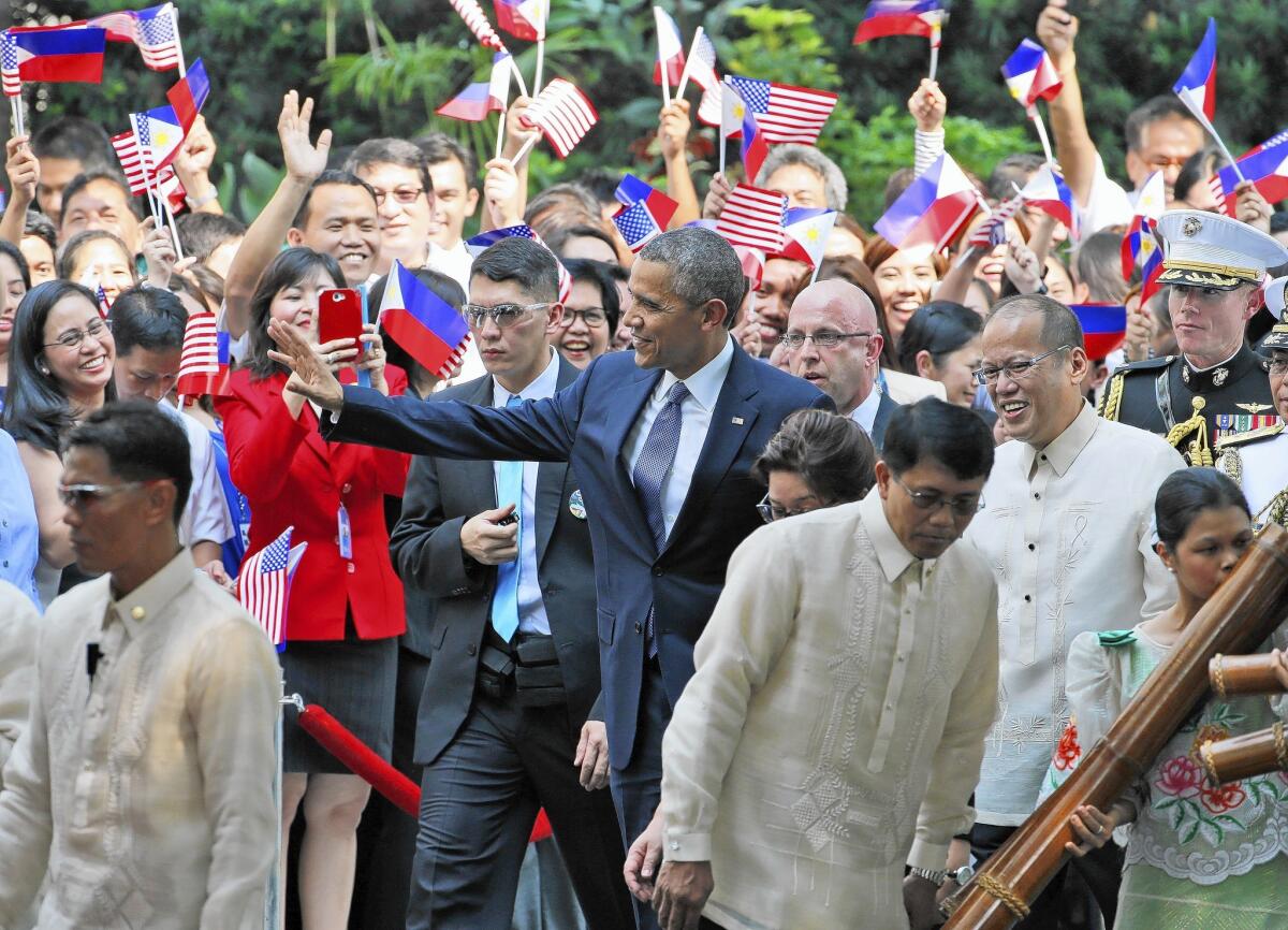 President Obama waves as he walks at Malacanang Palace in Manila. Obama was on the last stop of his four-nation Asian trip.