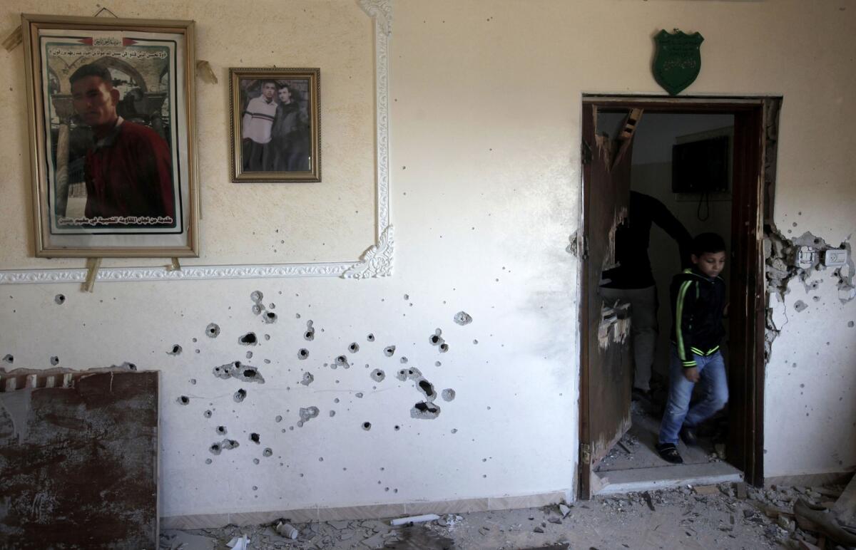 A boy inspects the bullet-riddled walls of the West Bank home where three Palestinians were killed in an Israeli military operation.