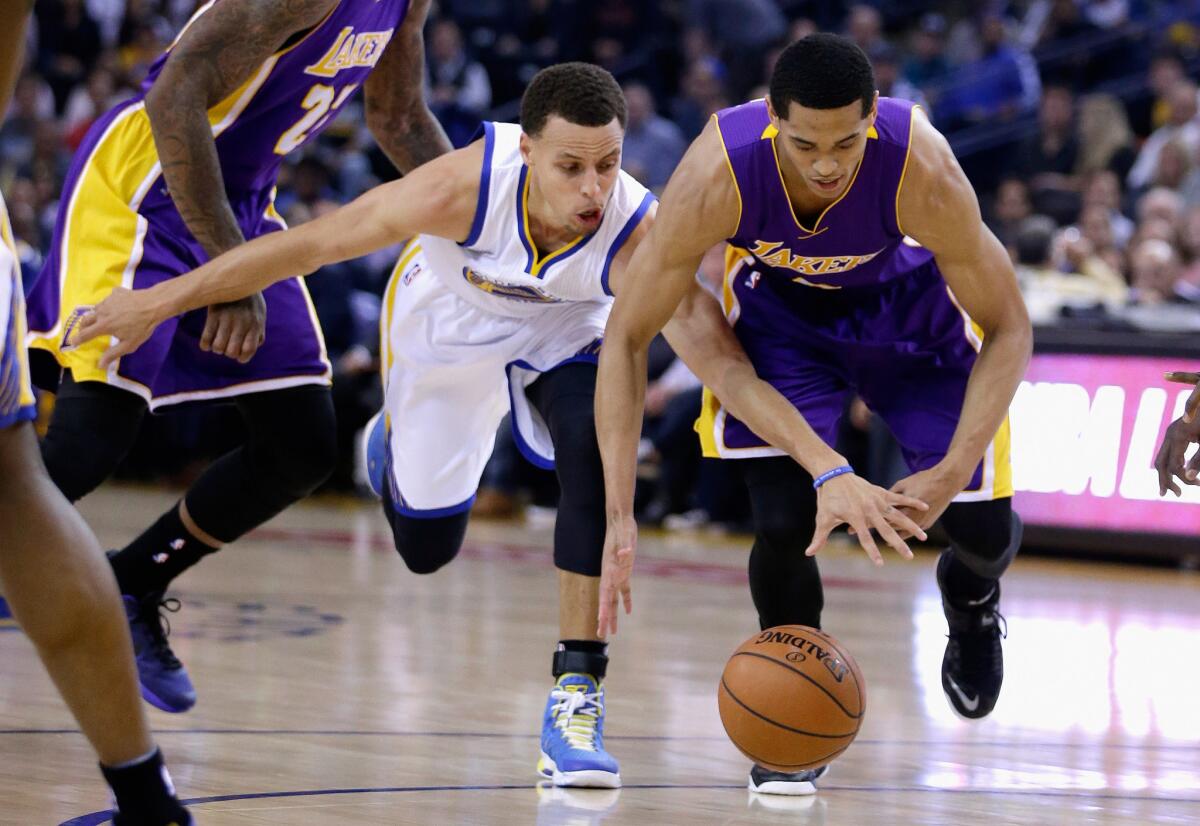 Warriors point guard Stephen Curry steals the ball from Lakers point guard Jordan Clarkson in the first half of the Warriors' 108-105 win at home.