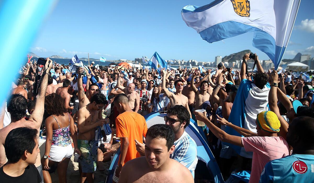 Soccer fan, many of them from Argentina, gather on Copacabana Beach before the championship game on Sunday.