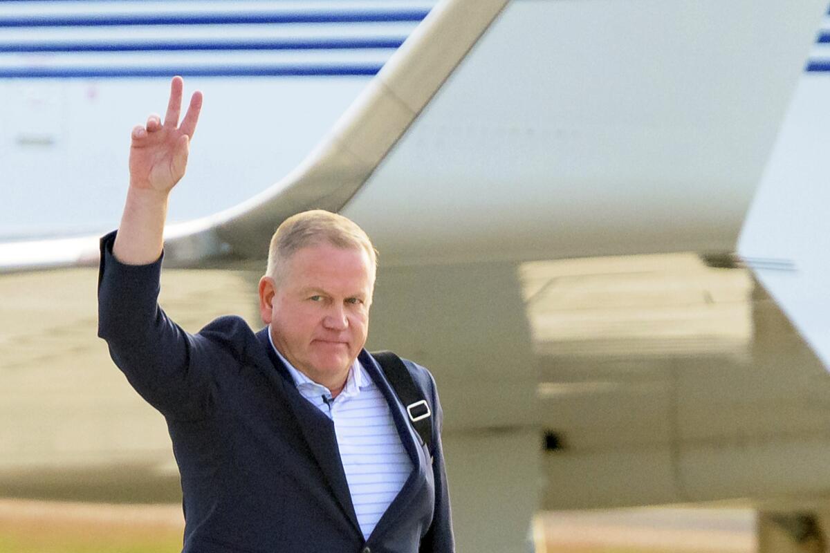 New Louisiana State coach Brian Kelly gestures to fans after his arrival at Baton Rouge Metropolitan Airport on Tuesday.