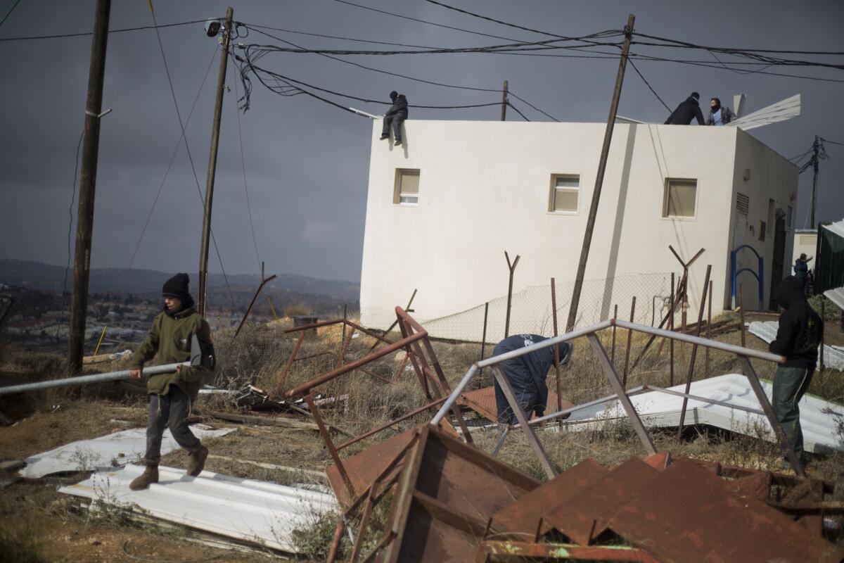 Jewish settler youths prepare barricades Dec. 15 to block the entrance to a building in Amona, an unauthorized Israeli outpost in the West Bank.