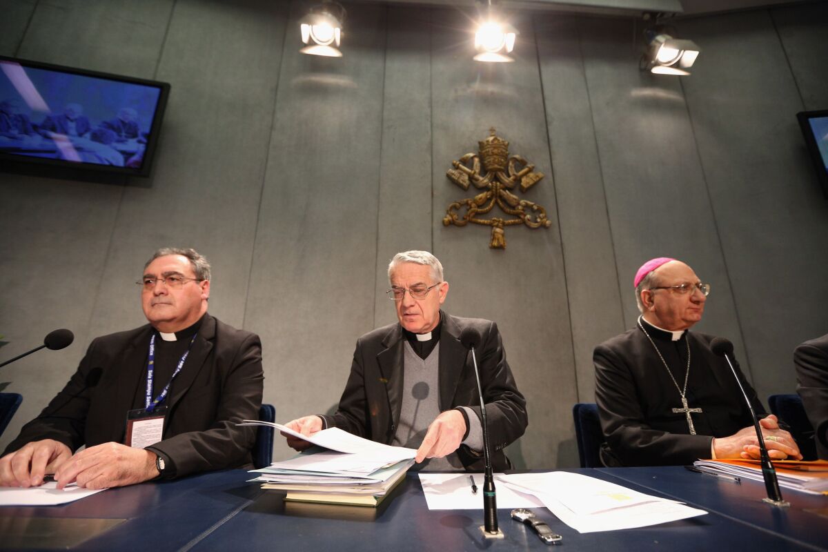 Father Federico Lombardi, center, director of the Holy See Press Office, along with Archbishop Pier Luigi Celata, right, hold a news conference at the Vatican to discuss changes to Roman Catholic Church law that will enable cardinals to select Pope Benedict XVI's successor sooner.