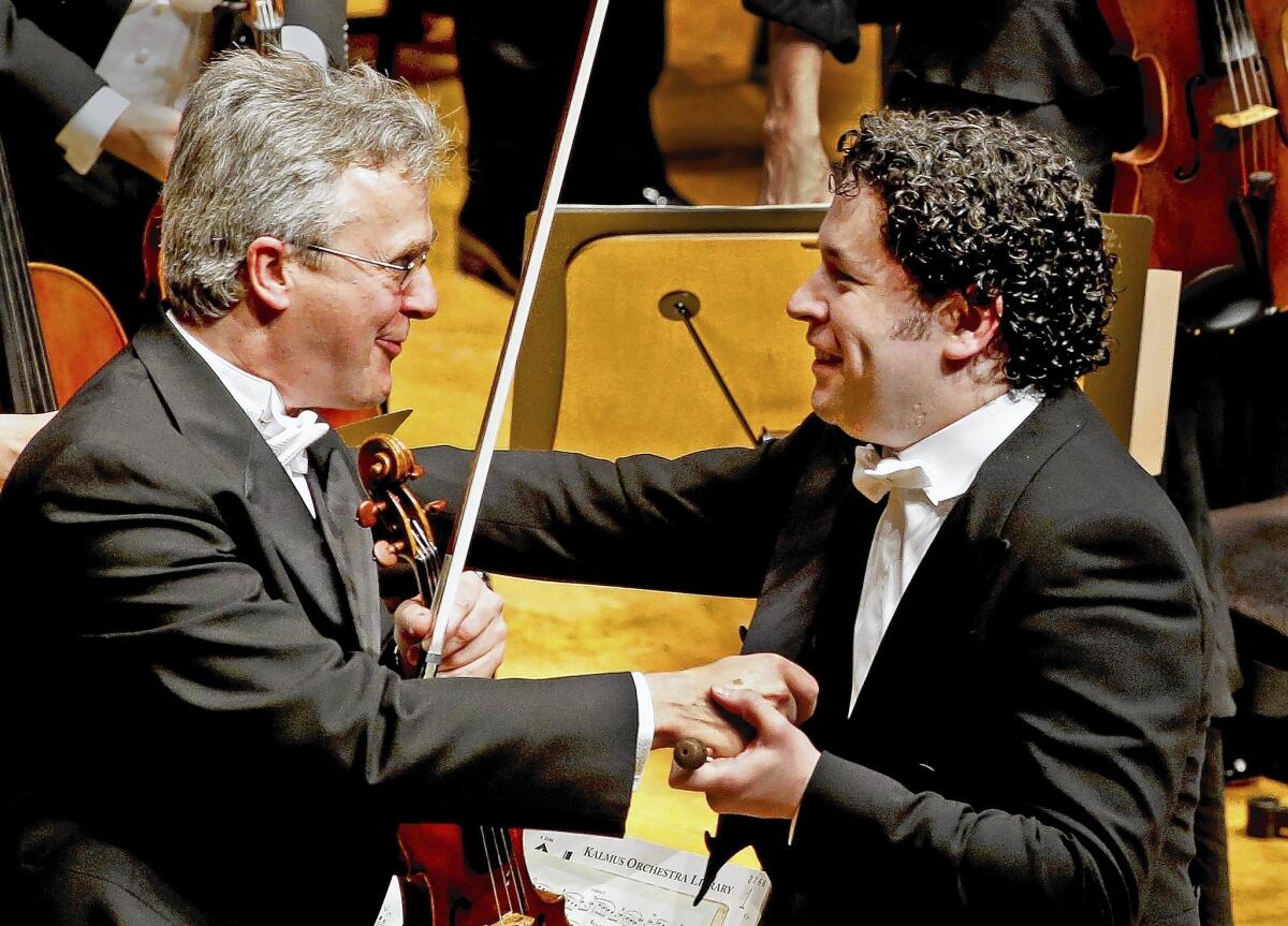 Gustavo Dudamel, right, shakes hands with first violin Martin Chalifour after Dudamel conducts the Simon Bolivar Symphony Orchestra of Venezuela and the Los Angeles Philharmonic.