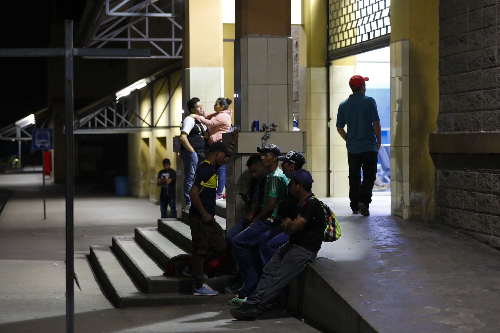 Men and women wait at night at the bus terminal in San Pedro Sula in Honduras.