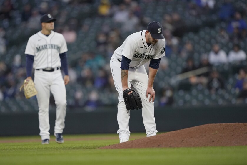 Seattle Mariners starting pitcher James Paxton, right, reacts near the mound after experiencing an injury during the second inning of a baseball game against the Chicago White Sox, Tuesday, April 6, 2021, in Seattle. Paxton left the game and the White Sox won 10-4. (AP Photo/Ted S. Warren)