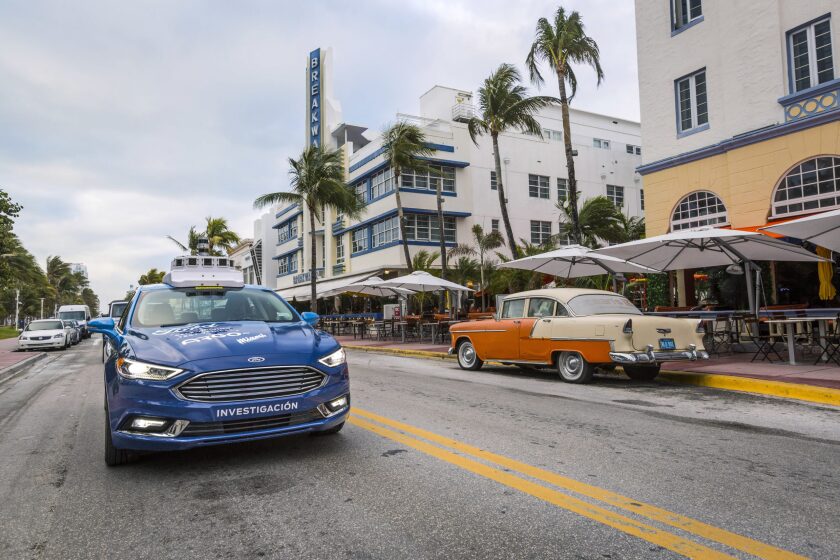 A self-driving Ford moves along a city street.
