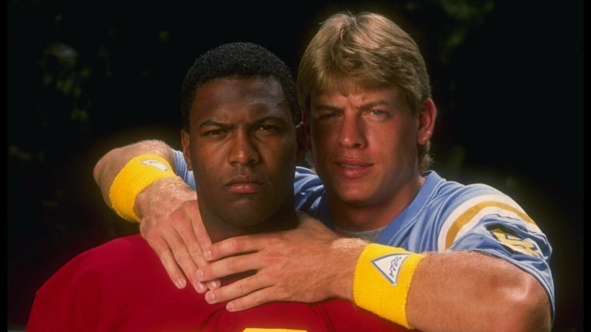 Quarterbacks Rodney Peete, left, of USC and Troy Aikman of UCLA clown around for the camera in 1988.