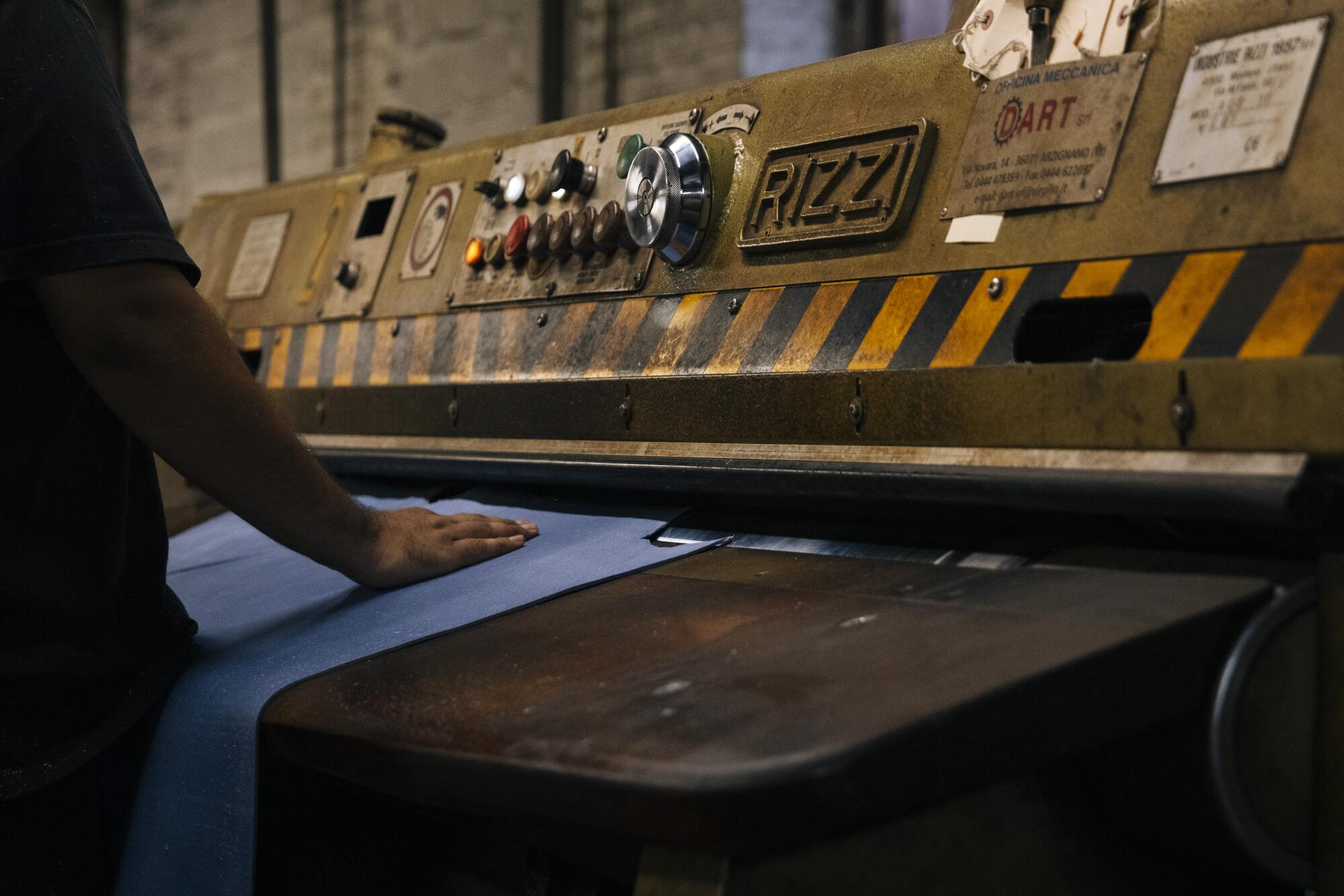 A worker at the Horween Leather Company pushes leather that will be used for basketballs through a shaving machine.