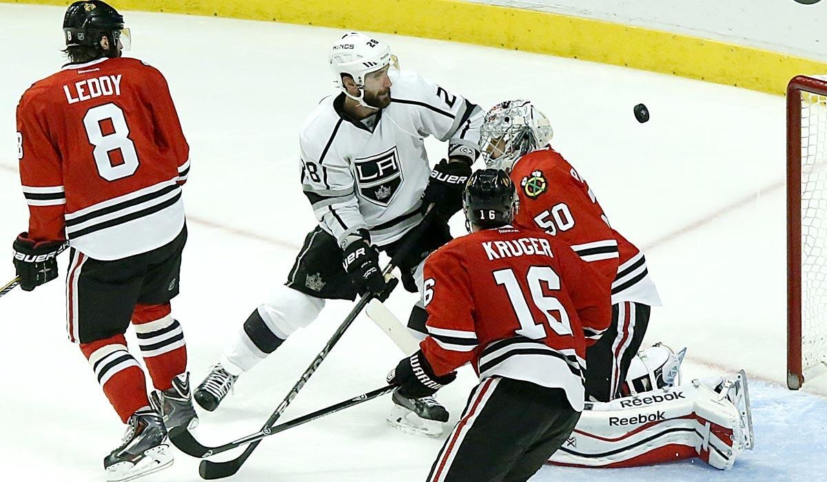 Kings center Jarret Stoll (28) watches the puck sail past Blackhawks goalie Corey Crawford for the winning goal in overtime in Game 7 on Sunday night in Chicago.