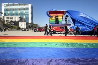 LONG BEACH, CA - JUNE 10: The wind made it slightly challenging for the unveiling of the new rainbow-colored lifeguard tower at Long Beach to replace the one that was burned down in March. The tower serves as a symbol of LGBTQ+ pride. Photographed on Thursday, June 10, 2021 in Long Beach, CA. (Myung J. Chun / Los Angeles Times)