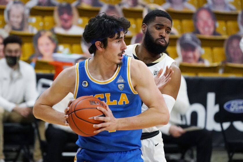 UCLA guard Jaime Jaquez Jr., front, pulls in a rebound in fornt of Colorado forward Jeriah Horne in the second half of an NCAA college basketball game Saturday, Feb. 27, 2021, in Boulder, Colo. Colorado won 70-61. (AP Photo/David Zalubowski)
