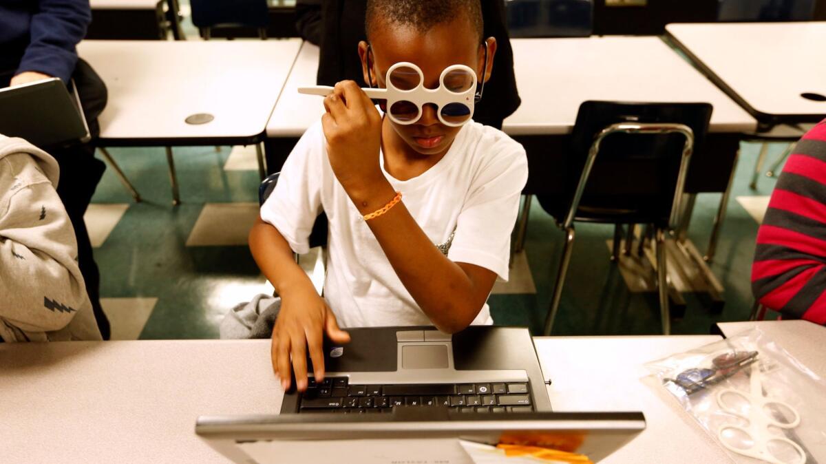 Shavalo Wooley, 8, uses 3-D glasses along with magnifying glasses while participating in a new program to improve children's reading skills by addressing problems with eye movement during the reading process at La Salle Avenue Elementary School in Los Angeles in March.