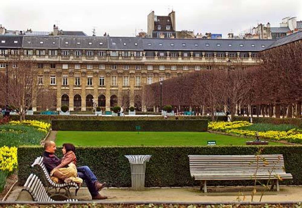 A couple enjoys the park with the Palais-Royal in Paris, in background, where Colette lived at the end of her life and was given a state funeral when she died in 1954.