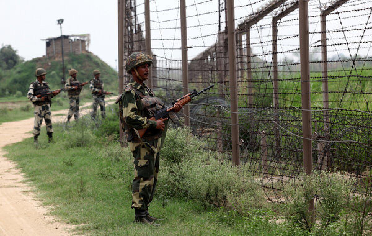 Indian soldiers stand guard along fencing near the Chachwal outpost along the border between India and Pakistan.
