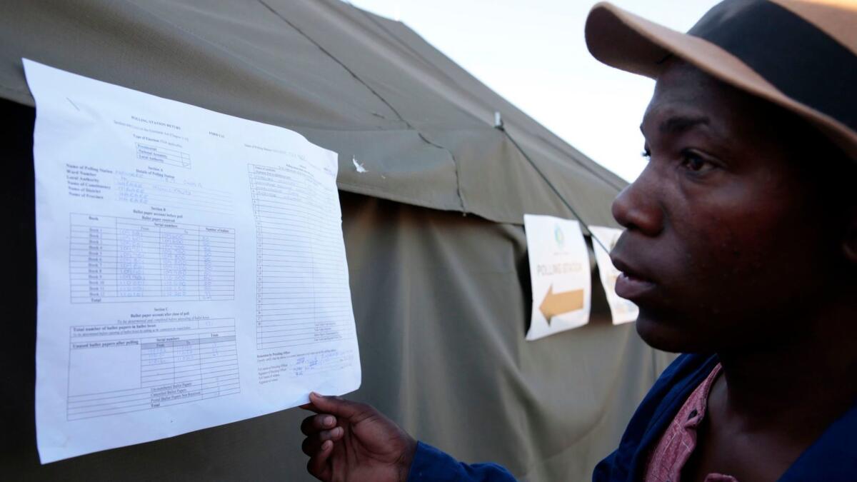 A resident checks on preliminary election results in Harare, Zimbabwe, on July 31.