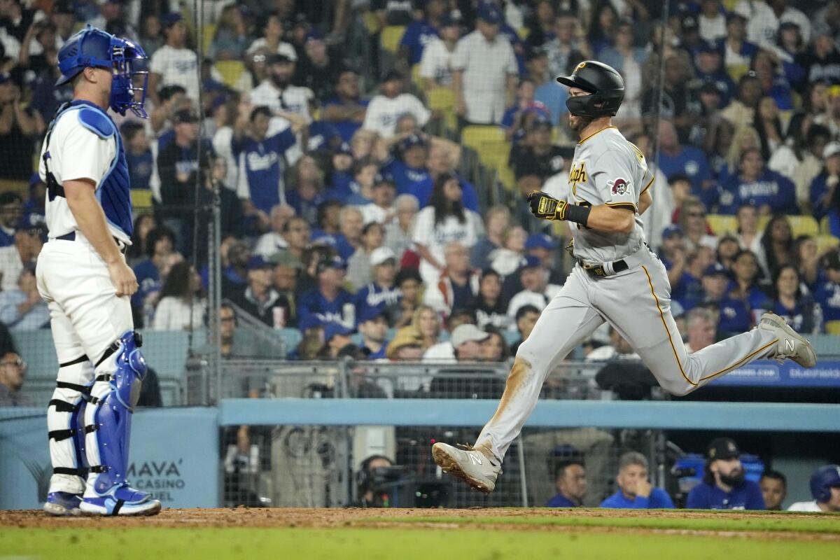 Pittsburgh Pirates' Jared Triolo scores on a double by Josh Palacios as Dodgers catcher Will Smith stands.