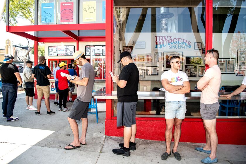 WEST HOLLYWOOD, CA - JULY 01: Customers wait to order in a growing line at the reopening of Irv's Burgers on Friday, July 1, 2022 in West Hollywood, CA. (Mariah Tauger / Los Angeles Times)