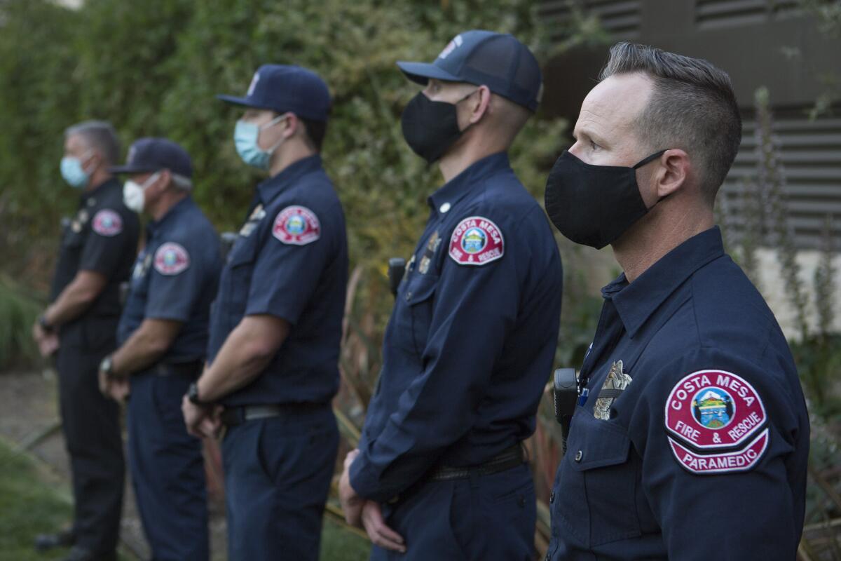 Members of Costa Mesa Fire and Rescue attend a public candlelight memorial. 