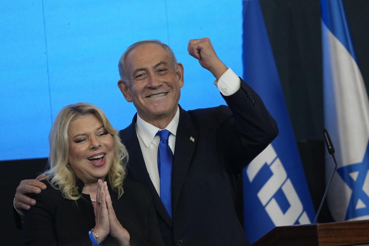 Former Israeli Prime Minister pumping his fist alongside his wife, Sara