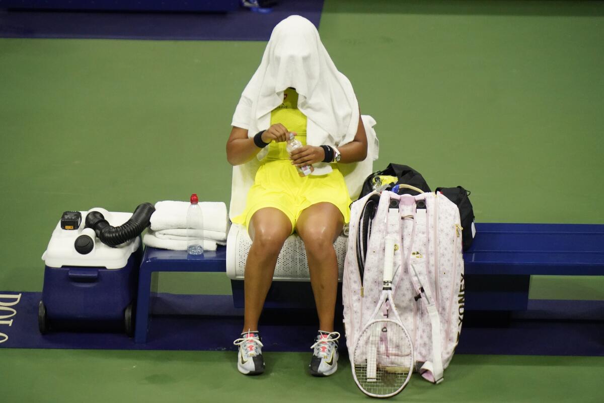 Naomi Osaka, of Japan, covers her head between games against Leylah Fernandez, of Canada, at the third round of the US Open tennis championships, Friday, Sept. 3, 2021, in New York. (AP Photo/Frank Franklin II)