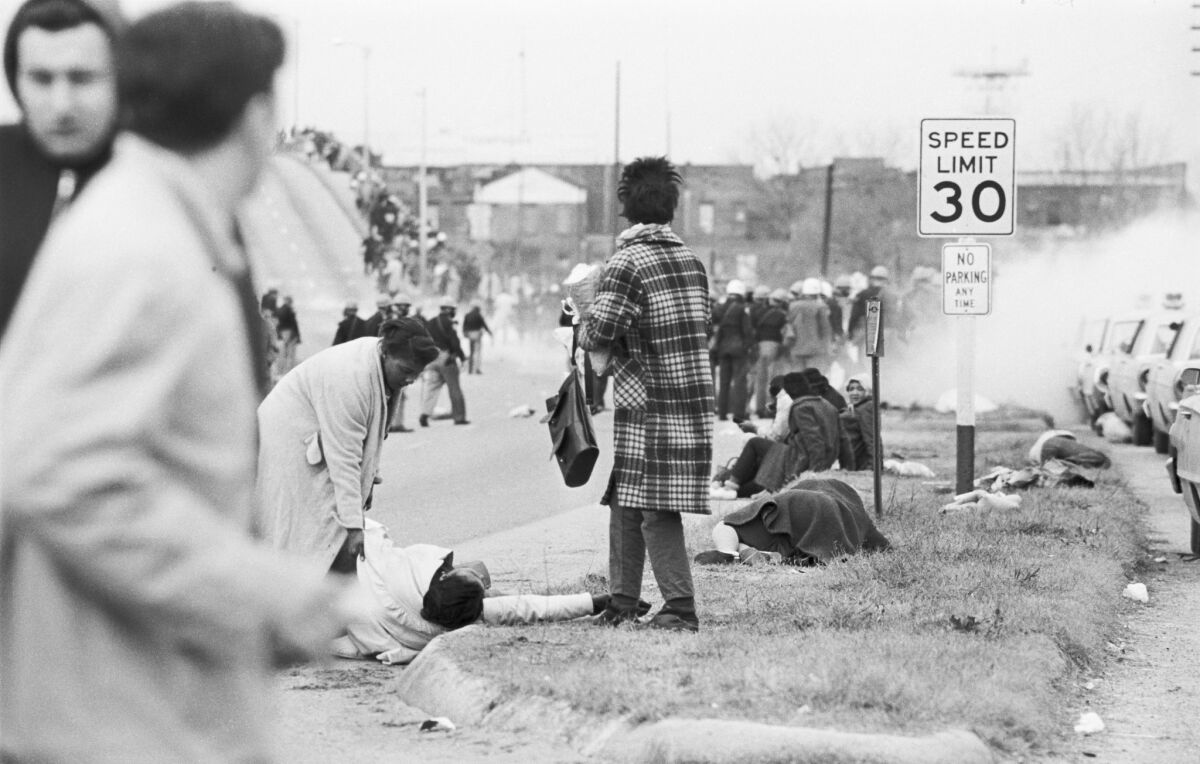 A woman looks on as Alabama state troopers, using tear gas, push peaceful demonstrators back toward the Edmund Pettus Bridge in Selma, Ala., on "Bloody Sunday" in 1965.