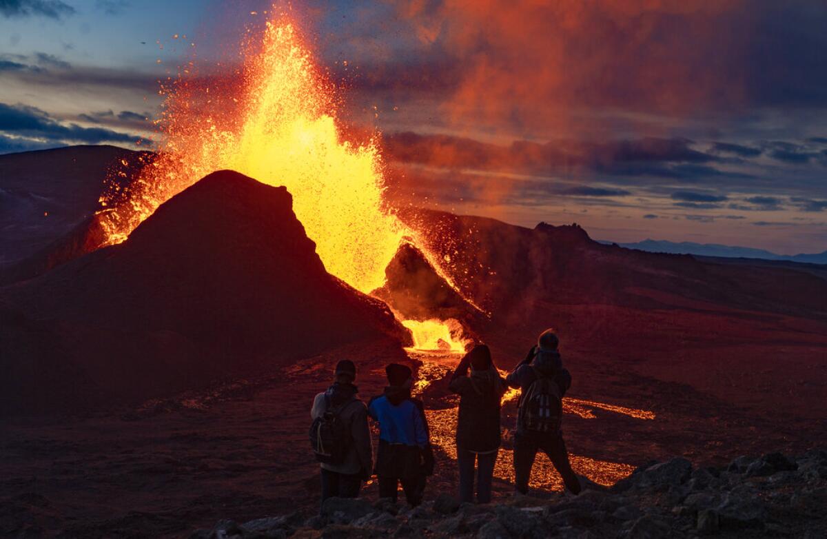 Gente mirando cómo sale la lava durante una erupción del volcán Fagradalsfjall,