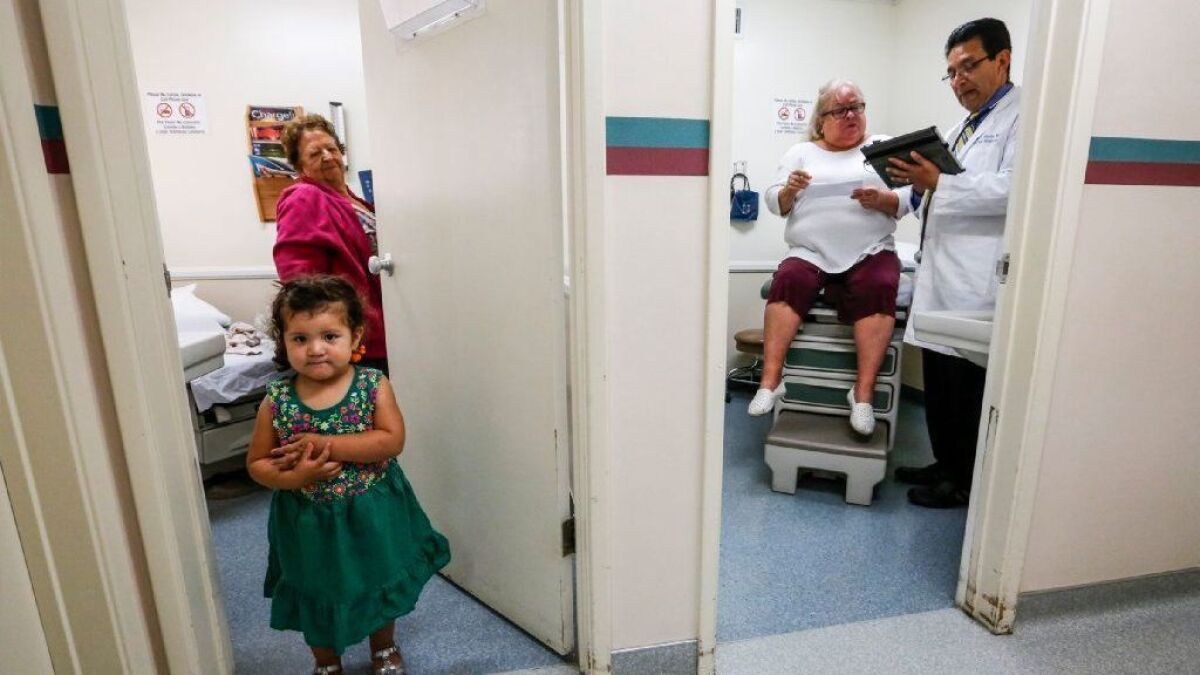 Daniella Gonzales, 2, and her grandmother Maria Gonzales wait for the next appointment while Dr. Juan Montes works with a patient next door in his Whittier office in 2017.