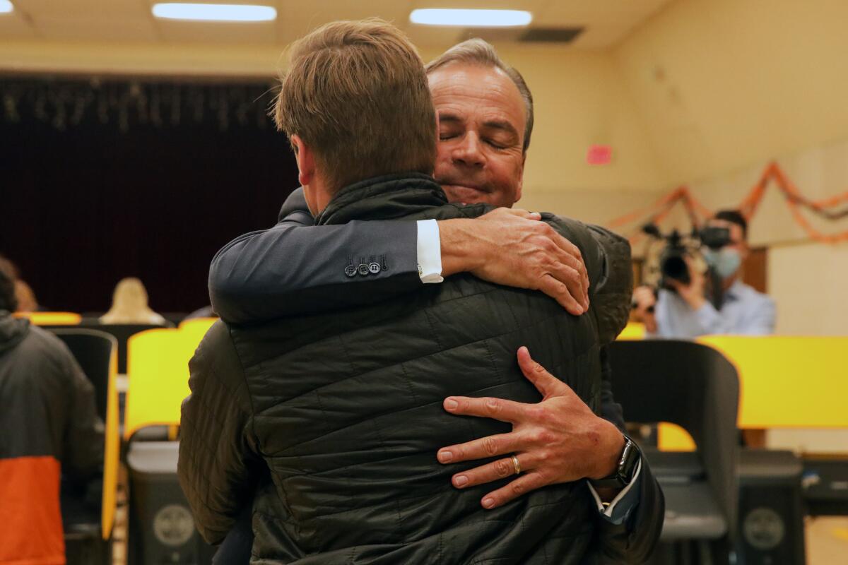 Rick Caruso hugs his son.