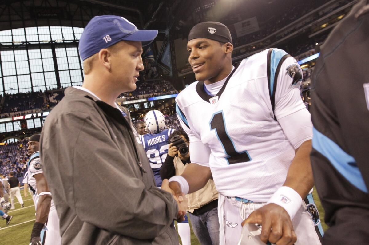 An injured Peyton Manning, then quarterback of the Indianapolis Colts, meets with Carolina quarterback Cam Newton after a game on Nov. 27, 2011.