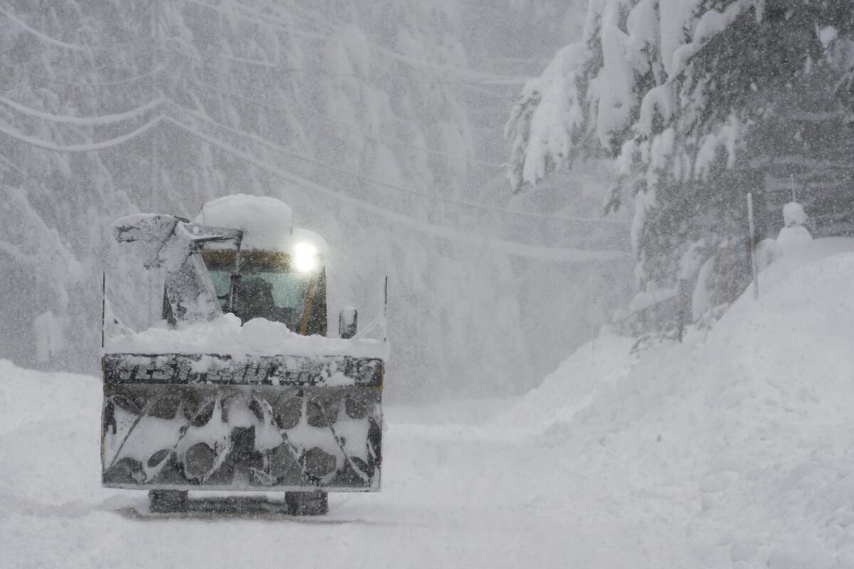 A snowplow is used to clear a road during a storm in Truckee on Saturday.