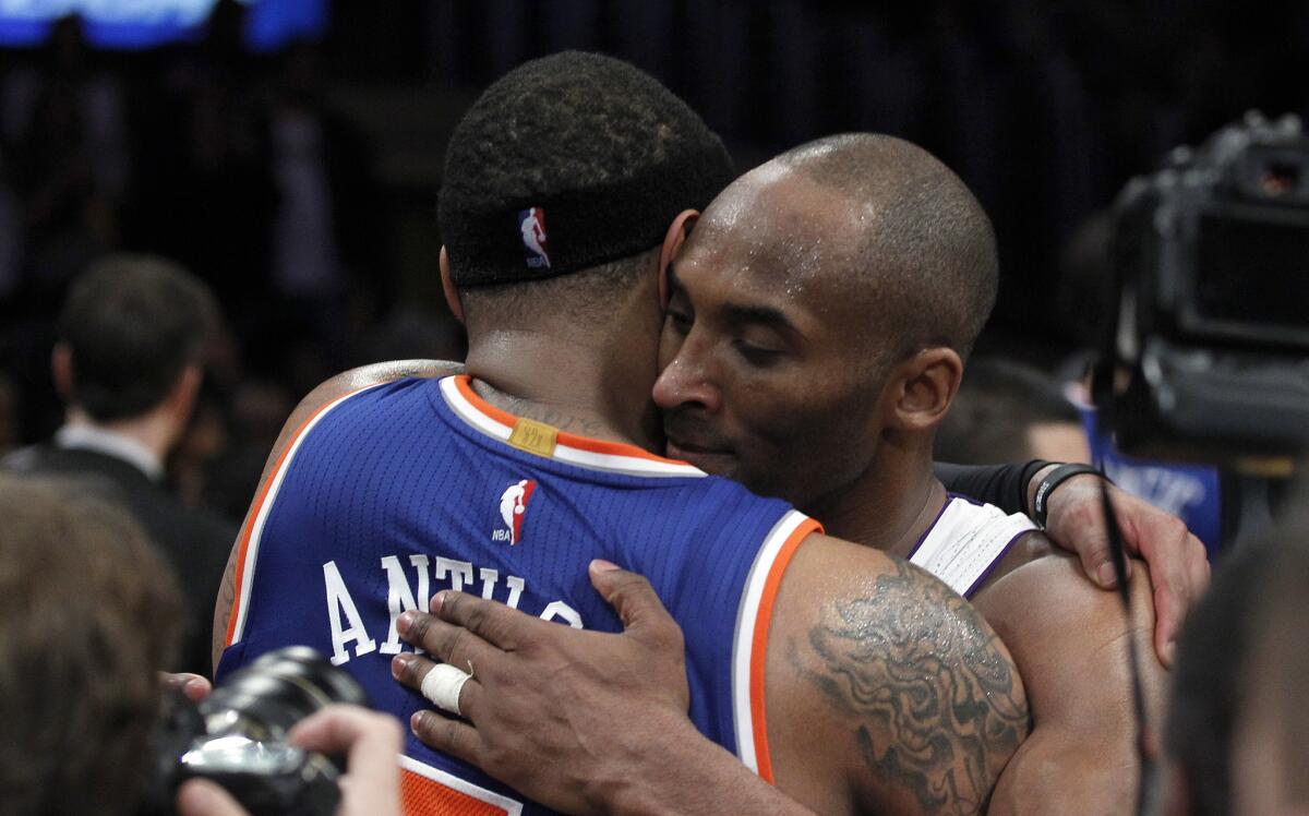 Kobe Bryant gives New York Knicks forward Carmelo Anthony a final postgame hug on Sunday.