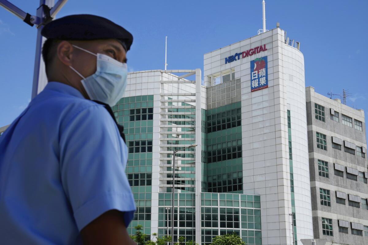 Police officer standing guard outside Apple Daily newspaper office