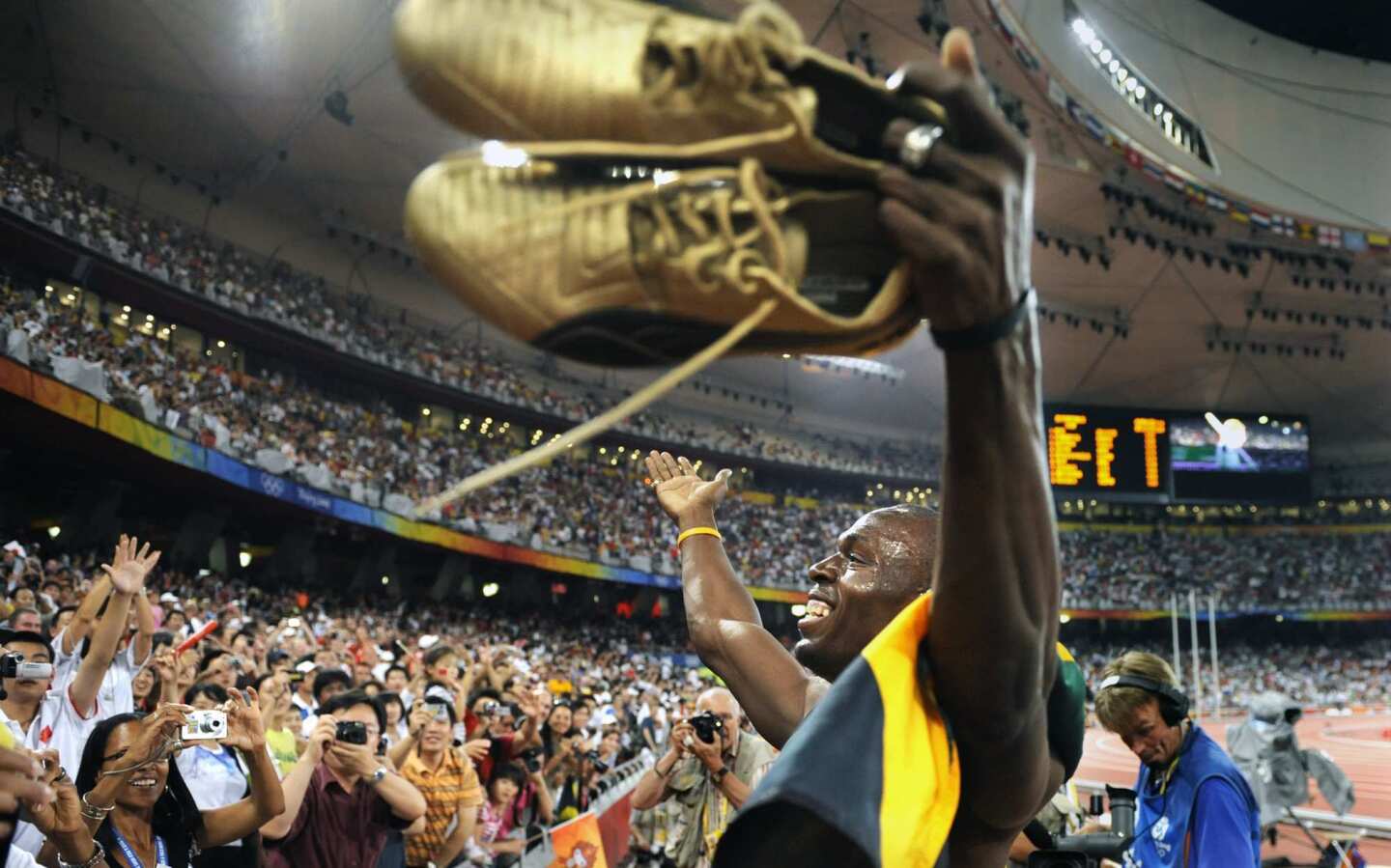 Usain Bolt celebrates with the crowd after Jamaica won the gold medal in the 400-meter relay at the 2008 Beijing Olympics.
