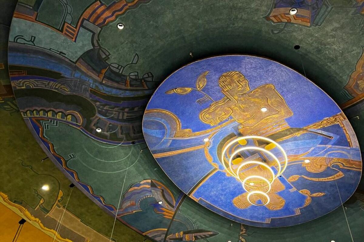 Vision Theatre's ceiling features male and female figures on a blue oval.