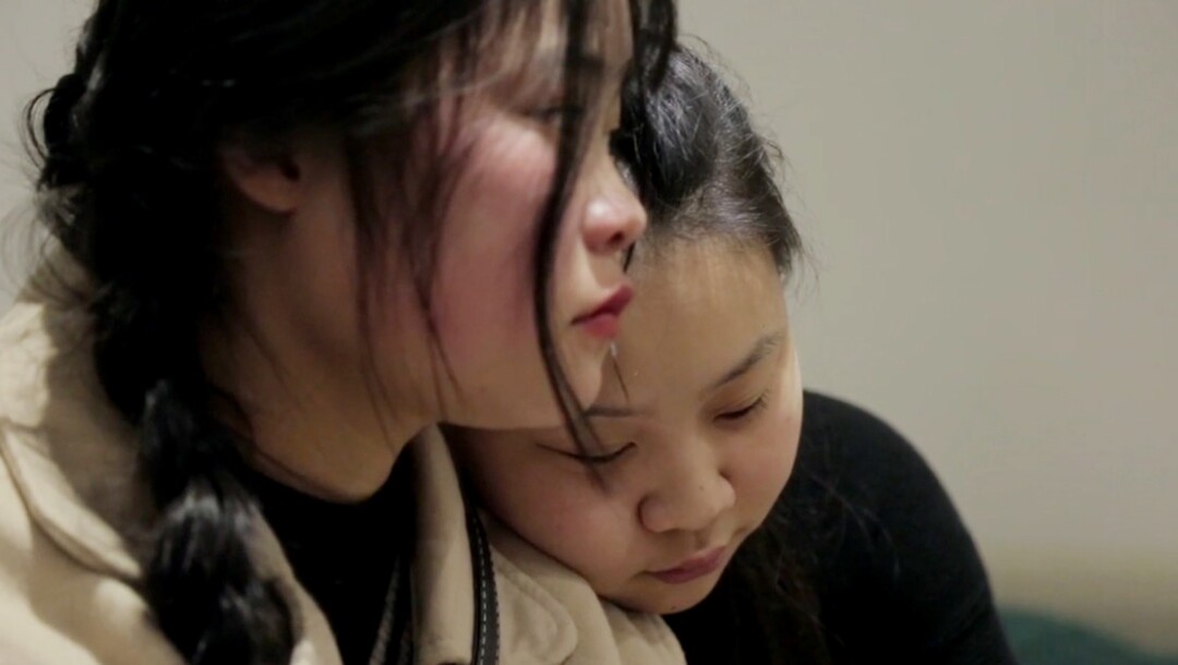 Esther rests her head on Shuangjie’s shoulder