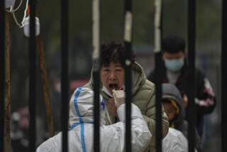 FILE - A woman has her routine COVID-19 test at a coronavirus testing site setup inside a residential compound in Beijing, Thursday, Nov. 24, 2022. (AP Photo/Andy Wong, File)