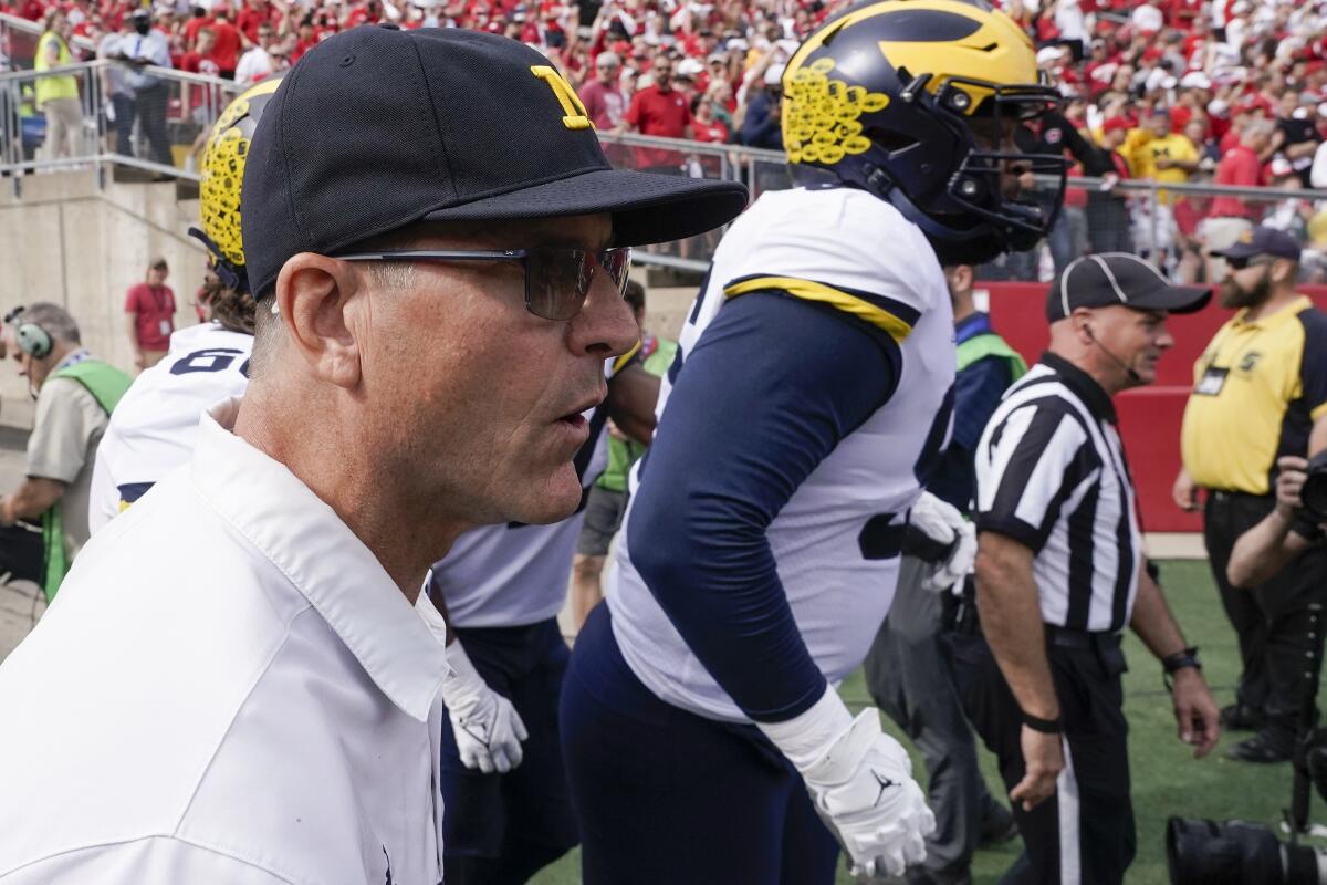 Michigan head coach Jim Harbaugh leads his team on the field before an NCAA college football game against Wisconsin Saturday, Oct. 2, 2021, in Madison, Wis. (AP Photo/Morry Gash)