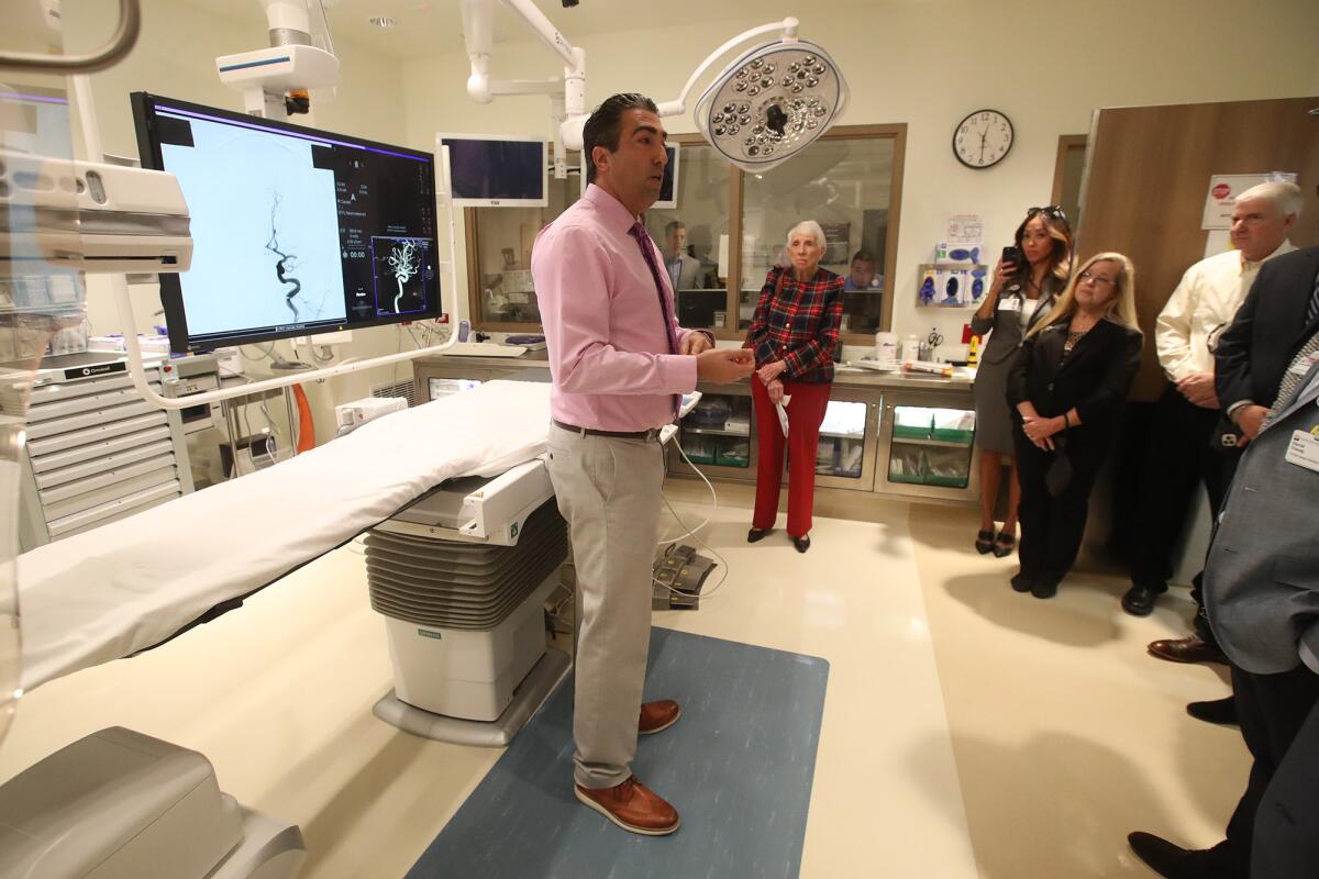 Dr. Hamed Farid explains the technology of the new neurointerventional angiography suite with hospital and city officials.