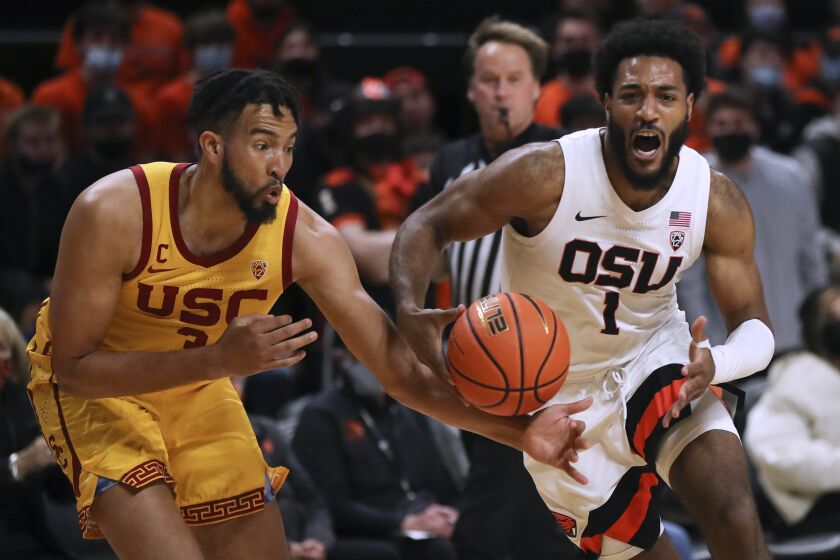 Southern California forward Isaiah Mobley, left, grabs for the ball as Oregon State forward Maurice Calloo drives during the first half of an NCAA college basketball game Thursday, Feb. 24, 2022, in Corvallis, Ore. (AP Photo/Amanda Loman)