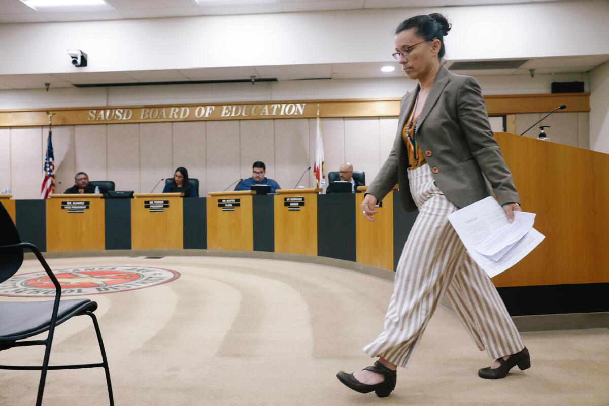 Robin Gurien returns to her seat after addressing Santa Ana Unified school board members.