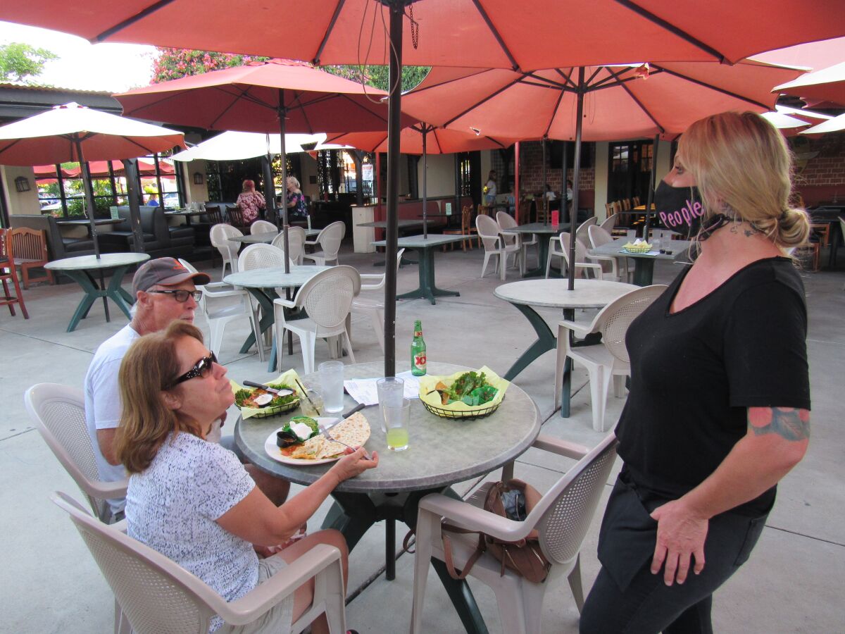  Melanie Brookes speaks with Karen and Ross Ellis at a patio table at the Downtown Cafe in El Cajon last year.