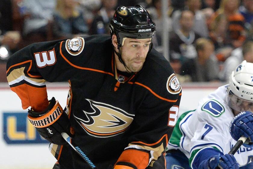 Ducks defenseman Clayton Stoner, left, clears the puck in front of Vancouver Canucks forward Linden Vey during a game on Nov. 9.