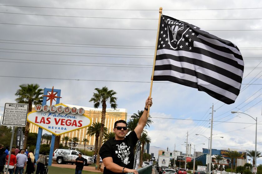 LAS VEGAS, NV - MARCH 27: Oakland Raiders fan Matt Gutierrez of Nevada waves a Raiders flag in front of the Welcome to Fabulous Las Vegas sign after National Football League owners voted 31-1 to approve the team's application to relocate to Las Vegas during their annual meeting on March 27, 2017 in Las Vegas, Nevada. The Raiders are expected to begin play no later than 2020 in a planned 65,000-seat domed stadium to be built in Las Vegas at a cost of about USD 1.9 billion. (Photo by Ethan Miller/Getty Images)