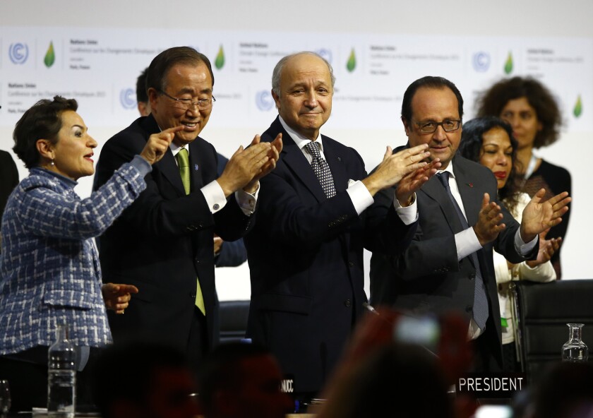 French President Francois Hollande, right, French Foreign Minister and president of the COP21 Laurent Fabius, second, right, United Nations climate chief Christiana Figueres and United Nations Secretary General Ban ki-Moon applaud after the final conference at the COP21, the United Nations conference on climate change, in Le Bourget, north of Paris, on Saturday. Governments have adopted a global agreement that for the first time asks all countries to reduce or rein in their greenhouse gas emissions.