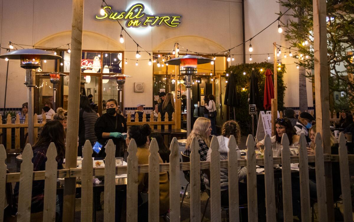 People dine outdoors at a restaurant in Huntington Beach.